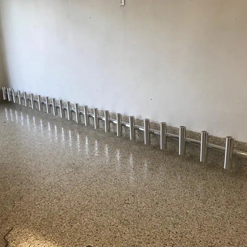 Aluminum wall-mount rod rack holding 25 rods for a fishing room